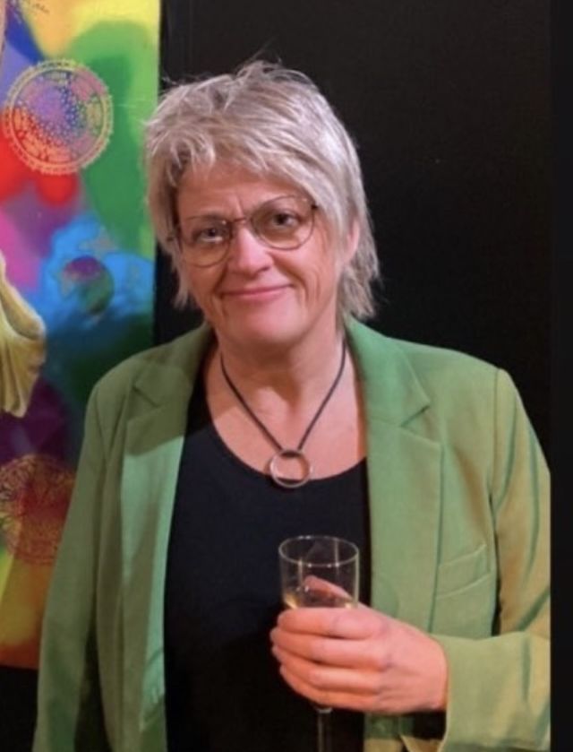 Nærbilde av Trine Midtlie Elmholt, smilende, i grønn jakke.